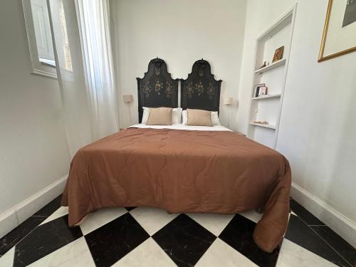 a bedroom with a large bed with a black headboard at Milonghita Apartment Ortigia by Ortigiaapartments in Syracuse