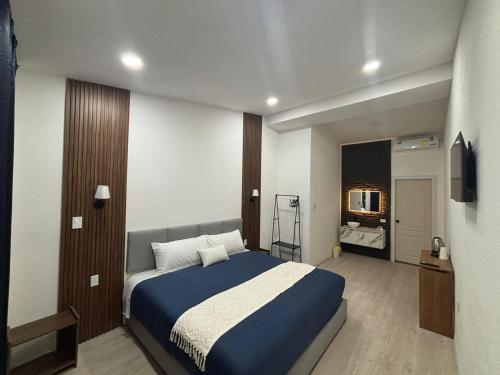 a bedroom with a large bed and a television at Borunda Suites in General Trías