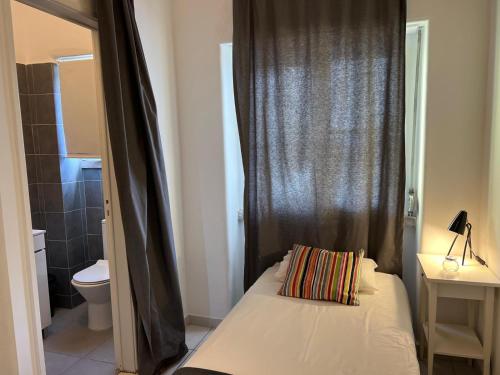 a small bedroom with a bed with a black curtain at Alvalade II Airport Guest House in Lisbon
