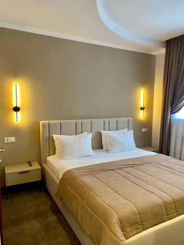 a bedroom with a large bed with white pillows at Grand Christer Hotel in Kyiv