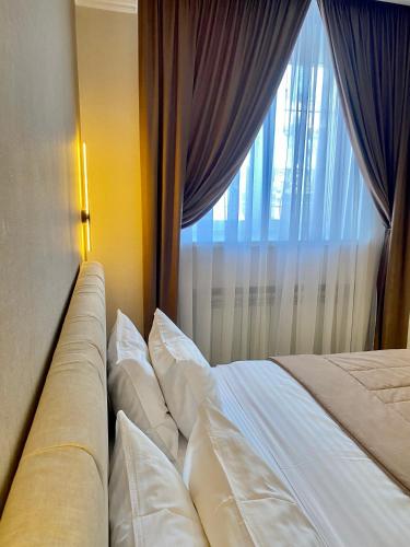 a bed with pillows in front of a window at Grand Christer Hotel in Kyiv
