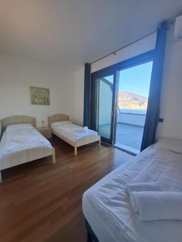 a bedroom with two beds and a large window at Villa Manuela-Lake View in Brenzone sul Garda