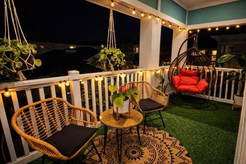 a porch with two chairs and a table and swings at Boho Boutique Retreat - Pool - Gym - Private Patio in Tampa