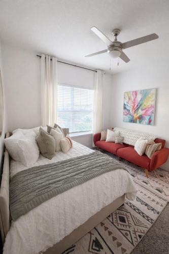 a bedroom with a large bed and a red couch at Boho Boutique Retreat - Pool - Gym - Private Patio in Tampa