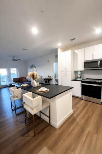 a kitchen and living room with a table and chairs at Boho Boutique Retreat - Pool - Gym - Private Patio in Tampa