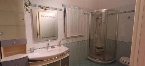 a bathroom with a sink and a shower at Charme rustico con ampio giardino e piscina con due camere in Carrara