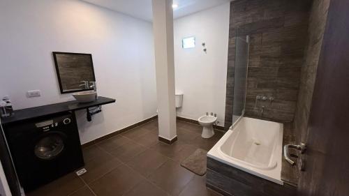 a bathroom with a shower and a toilet and a sink at Softi Sur in Comodoro Rivadavia