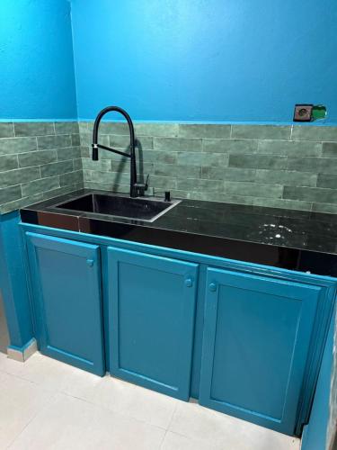 a kitchen with blue cabinets and a sink at Hostel & Riad in Essaouira