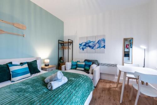 a bedroom with a bed and a couch and a table at Glan Neigr Apart-Hotel by Guestz in Rhosneigr