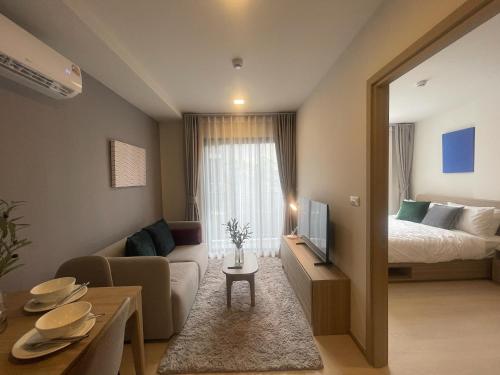 a hotel room with a bed and a living room at Rest&Rise Phuket in Ban Rangeng