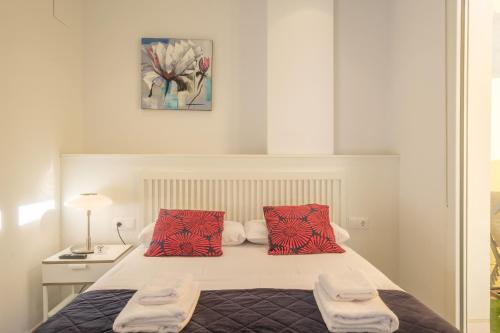a bedroom with a bed with two red pillows at Gorgeous Apt with a Large Private Terrace in Valencia