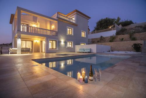 a villa with a swimming pool in front of a house at Villas Guzman - Grandiosa in Calpe