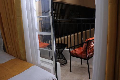 a room with a balcony with a bed and a chair at Kwetu properties in Nairobi