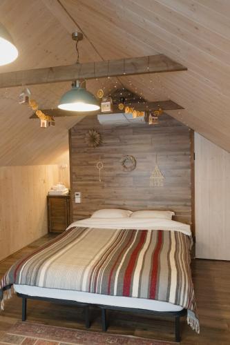 a bedroom with a large bed with a wooden wall at Aglamp Almaty in Besqaynar