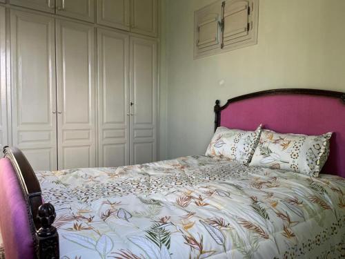 a bedroom with a bed with a pink head board at Le Typique Djerbien in Houmt Souk
