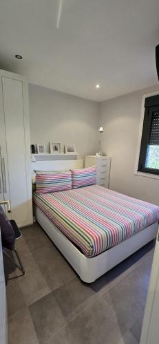 a bedroom with a large bed with a striped comforter at Casa Arena 2 in Nigrán