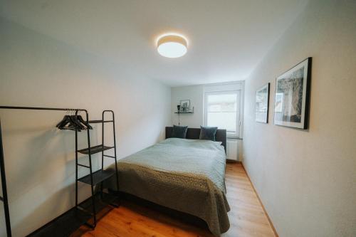 a small bedroom with a bed and a lamp at Spatzennest am Taubenhaus Residenz Moselliebe in Traben-Trarbach