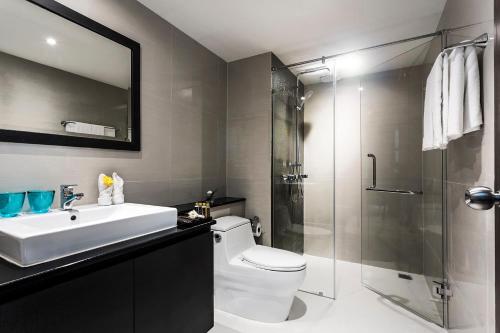 Un baño con inodoro, lavabo y ducha. en Unique Regency Pattaya, en Pattaya South