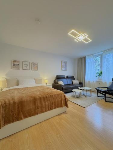 a large bedroom with a bed and a couch at Dein Apartment mit Queensize Bett im Erdgeschoss in Neukirchen-Vluyn