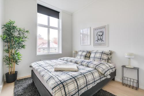 a white bedroom with a bed and a window at Spacious Five Bedroom Central Oslo in Oslo