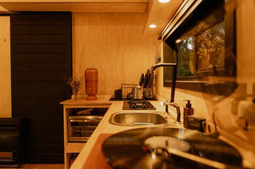 a kitchen with a sink and a stove at Cabana Fora in São Francisco de Paula