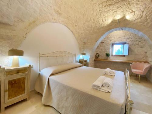 a bedroom with a bed with towels on it at Trullo al borgo in Cisternino