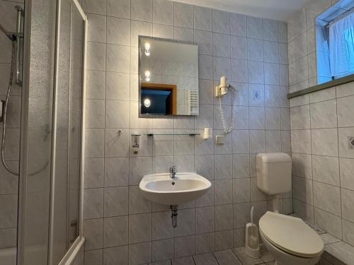 a bathroom with a sink and a toilet and a mirror at Hotel Zum Kanzler in Stolberg