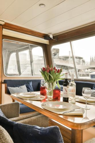 a table with wine glasses and flowers on a boat at Authentic houseboat Amalia in Amsterdam