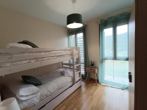 a room with two bunk beds and a window at Inmocyma Los Almendros in Castejón de Sos
