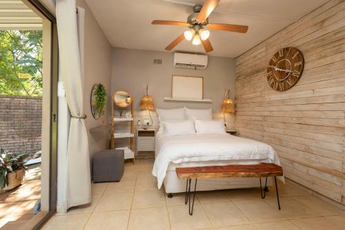 a bedroom with a bed and a ceiling fan at The Old Stone House in Kloof