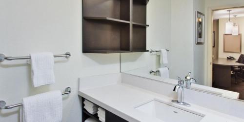 a white bathroom with a sink and a mirror at Sonesta Simply Suites Detroit Ann Arbor in Ann Arbor
