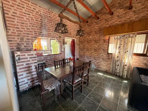 a dining room with a wooden table and chairs at Complejo Samaya in San Clemente del Tuyú