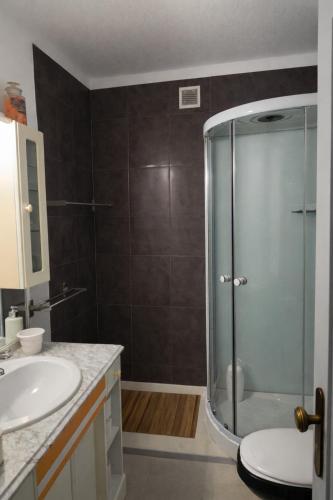 a bathroom with a glass shower and a sink at Estudio Boho Mar in Praia da Rocha