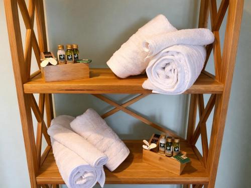 a wooden towel rack with towels and bottles on it at Villa Aniley in Ratzaklíon