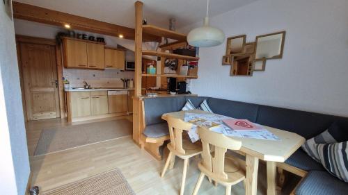 a living room with a table and a kitchen at Haus am Stein in Finkenberg