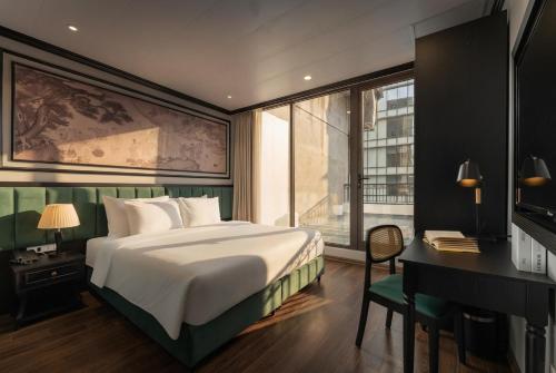 a bedroom with a bed and a desk and a computer at Embrace Boutique Hanoi Hotel in Hanoi