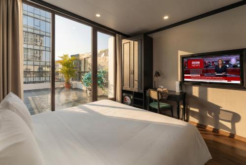 a bedroom with a bed and a flat screen tv at Embrace Boutique Hanoi Hotel in Hanoi