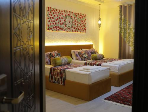 a hotel room with two beds and a couch at Oasis al Khiva Boutique Hotel Inside Citadel in Khiva