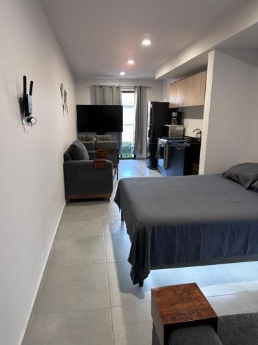 a bedroom with a bed and a living room at Moderno Loft Primer Cuadro Centro Historico Guadalajara in Guadalajara