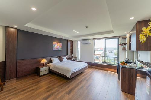 a bedroom with a bed and a large window at Nhà Nghỉ Chiếc Nón in Thôn Dương Xuân Hạ