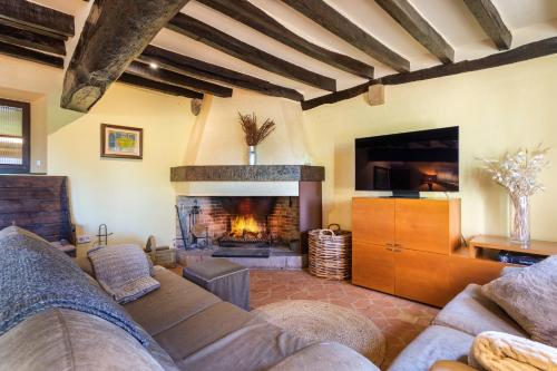 a living room with a couch and a fireplace at Villa privada de lujo Can Riera in Pujals dels Cavallers