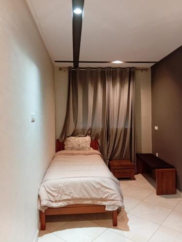 a bed in a room with a curtain at Annakhil 30 in Oulad Akkou