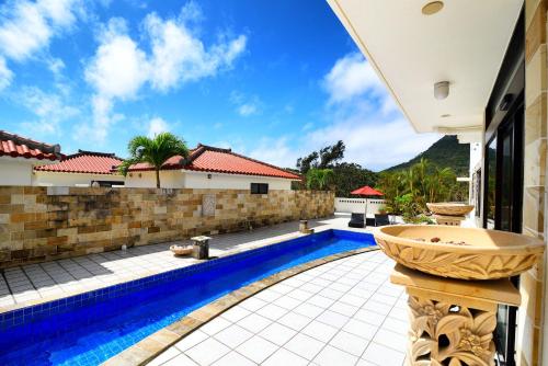 a swimming pool in the backyard of a house at Glamping Resort Yokabushi in Ishigaki Island