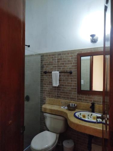 a bathroom with a toilet and a sink and a mirror at Casa Del Curato in Cartagena de Indias