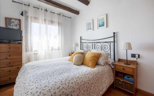a bedroom with a bed with pillows and a television at Casa Tossa – Piscina, Vistas Mar y A/C (6 pax) in Tossa de Mar