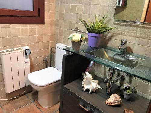 a bathroom with a toilet and a sink at Casa Tossa – Piscina, Vistas Mar y A/C (6 pax) in Tossa de Mar