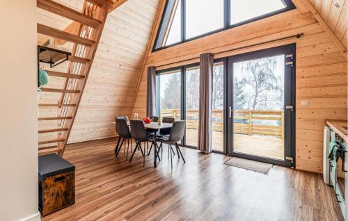 a dining room with a table and chairs and large windows at Confortable Chalet Moderne in Anould