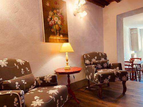 a room with two chairs and a table with a lamp at La Torretta in Laterina