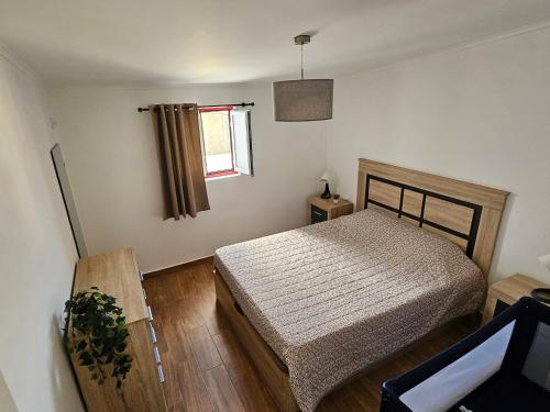a bedroom with a bed and a window at Casa do Aconchego em Freiria in Freiria