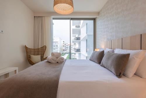 a bedroom with a large bed with a large window at Bayline - Bezugo by Bedzy in Armação de Pêra